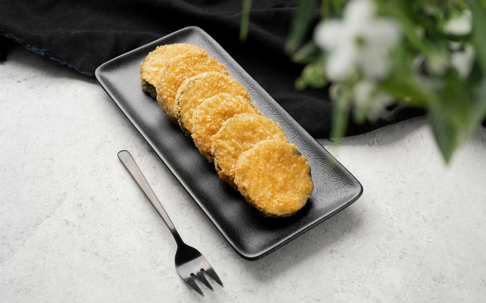Sylvan Foods breaded Eggplant cutlets — the flagship IQF product, plated for institutional presentation.